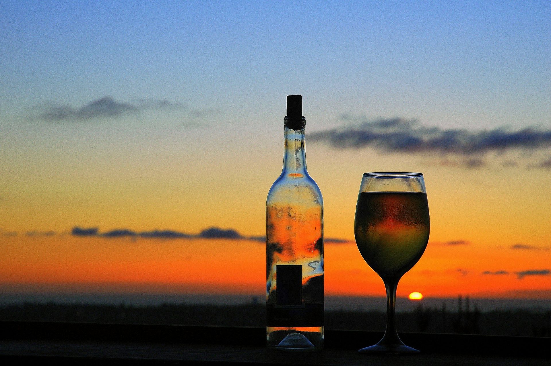 a bottle of wine next to a glass of wine